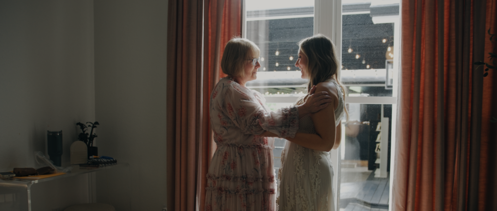 Dallas Wedding Videographer | Kaitlin and Isaiah | The Emerson Venue Wedding - Mom helping bride in her dress