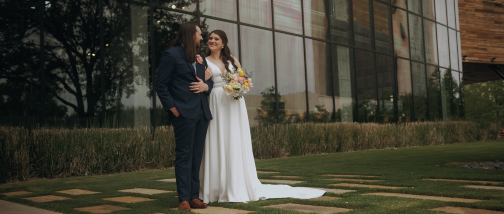 Dallas Wedding Videographer | Dana and Jordan | Watermark Church and HALL Arts Museum Wedding - Couple standing outside of Watermark Church