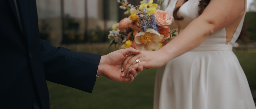 Dallas Wedding Videographer | Dana and Jordan | Watermark Church and HALL Arts Museum Wedding - Bride and Groom holding hands showing off ring