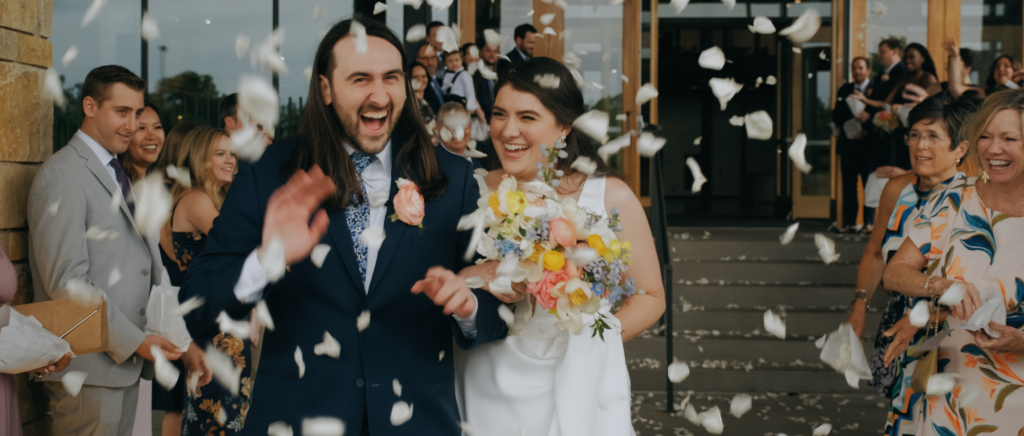 Dallas Wedding Videographer | Dana and Jordan | Watermark Church and HALL Arts Museum Wedding - Ceremony exit with flower pedals thrown