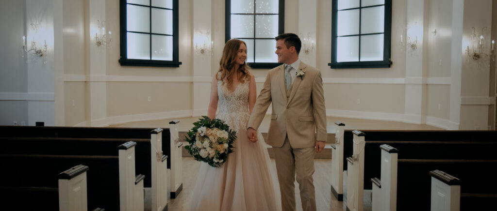 Dallas Wedding Videographer | Ryleigh and Noah | Aristide in Colleyville, TX - couple looking into each other's eyes as they walk down the chapel aisle