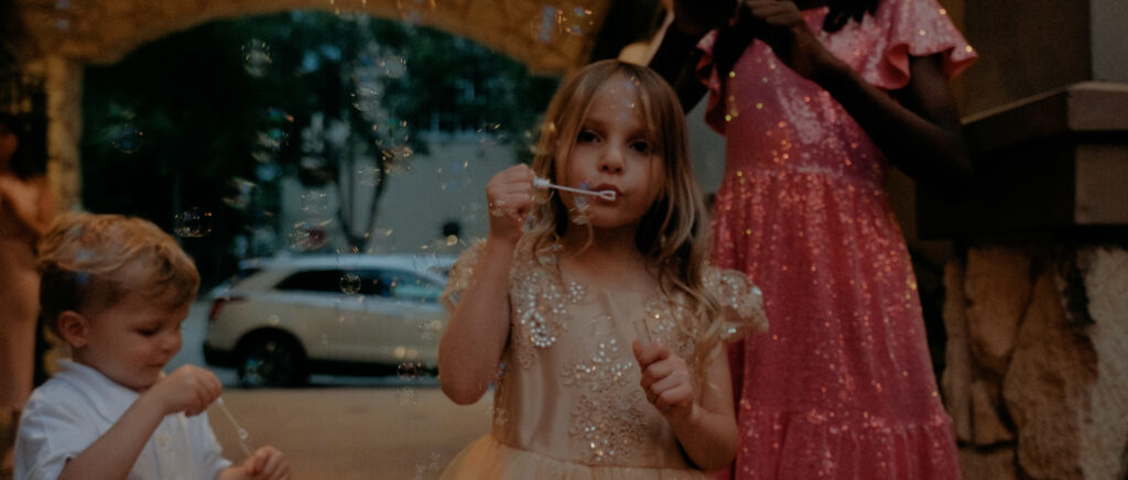 Dallas Wedding Videographer | Ryleigh and Noah | Aristide in Colleyville, TX - young girl blowing bubbles before send off