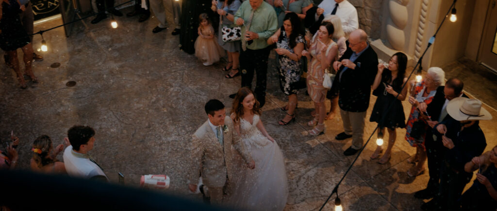 Dallas Wedding Videographer | Ryleigh and Noah | Aristide in Colleyville, TX - bird's eye view as the couple exits with bubbles all around