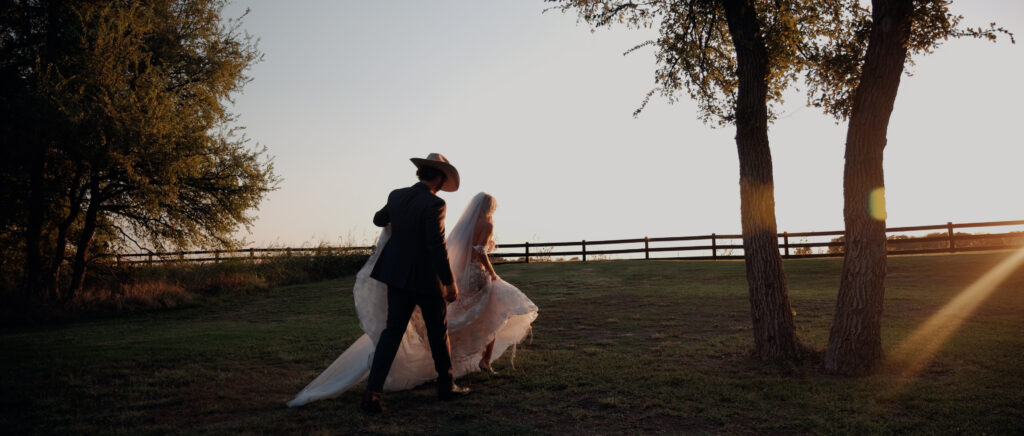Dallas Wedding Videographer | Brianna and Carter | The Springs Event Venue in Alvarado, TX - couple walking at sunset