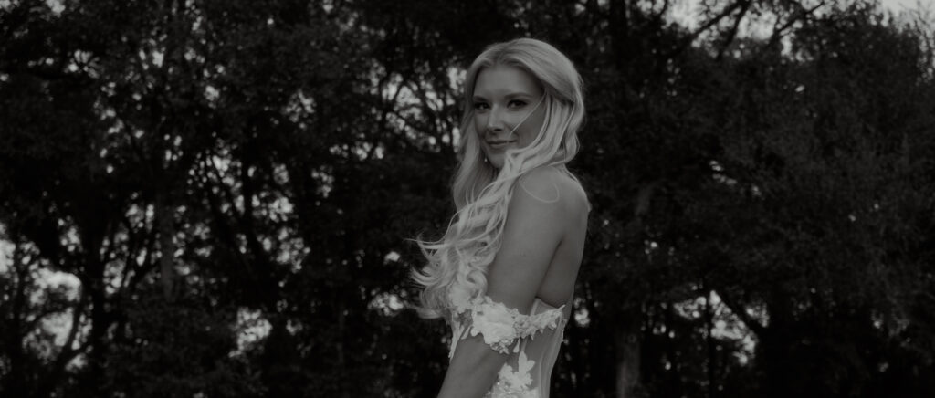 Dallas Wedding Videographer | Brianna and Carter | The Springs Event Venue in Alvarado, TX - bride in black and white with hair blowing in front of face