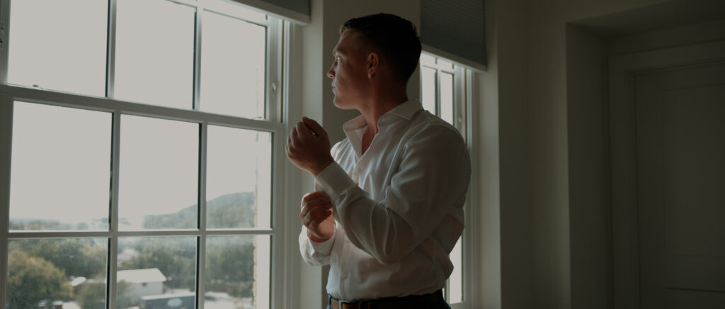 Videography for Wedding Dallas | Tegan and Dayd | - Crazy Water Hotel Wedding Video - groom adjusting cuff in front of window