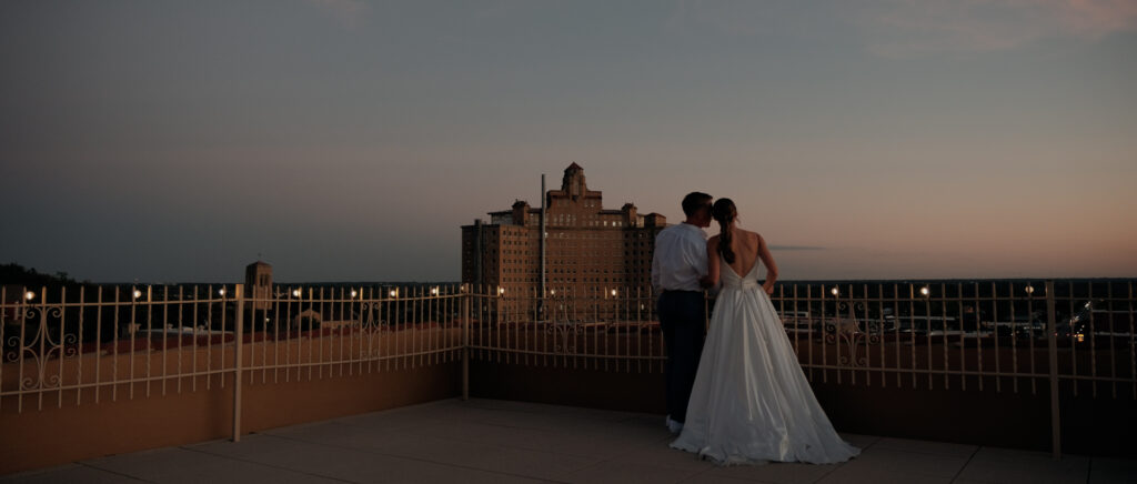 Videography for Wedding Dallas | Tegan and Dayd | - Crazy Water Hotel Wedding Video - Bride and groom overlooking the view of the rooftop at blue hour